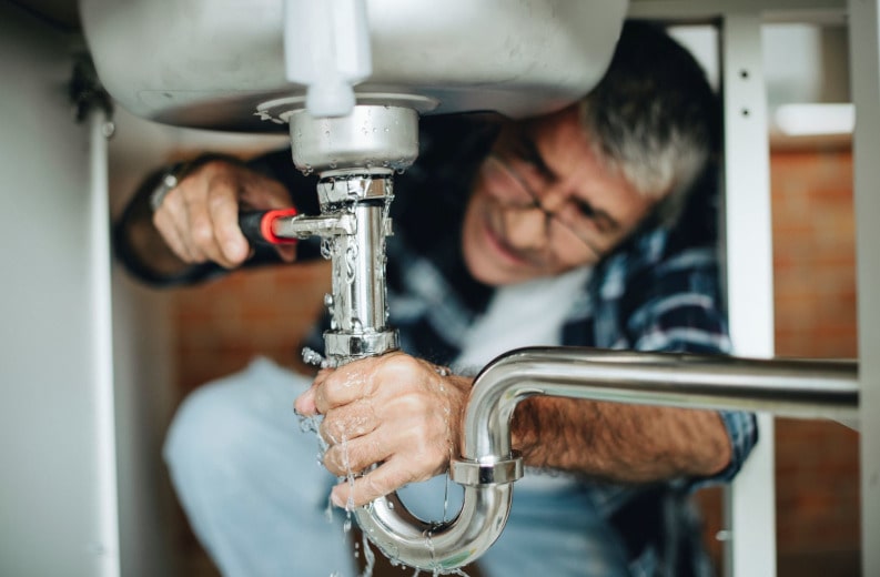 Plumber fixing the kitchen sink tips min